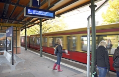 S-Bahnsteig mit Zug und Fahrgästen.