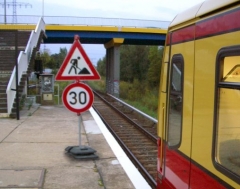 S-Bahn vor Geschwindigkeitsbegrenzungs-Schild für Baustellen auf Straßen